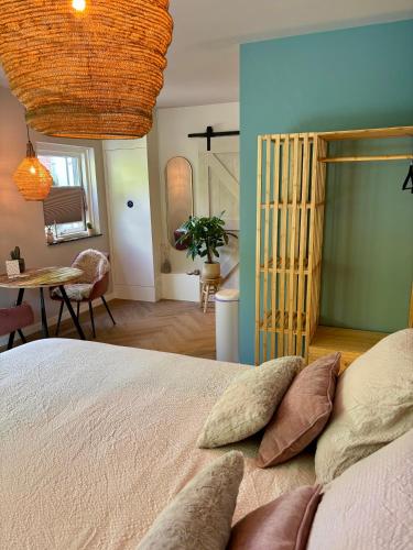 a bedroom with a bed with pillows and a table at Bij Julia in Den Burg