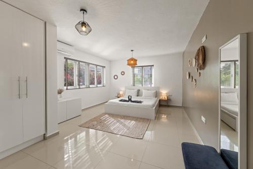 ein weißes Wohnzimmer mit einem weißen Sofa und Fenstern in der Unterkunft Villa Kaminda - 8 persoons Villa in Vista Royal, Jan Thiel in Jan Thiel