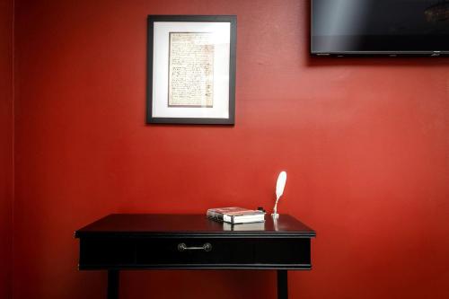 a red wall with a black table with a book on it at Relaxing Shenandoah Valley Stay with Scenic Views in Luray, Virginia in Luray