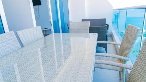 a glass table and chairs in a room at Reserva Del Mar Apartamentos in Gaira