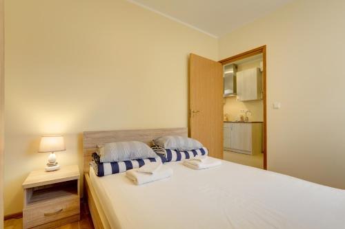 a bedroom with a large white bed with two pillows at Hommiku 8a Apartment in Pärnu