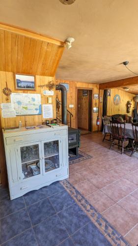 a living room with a fireplace and a table at Grangette Entre Chiens et Loups in LʼAnse-Saint-Jean