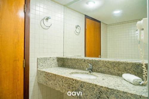 a bathroom with a sink and a mirror at Interatlântico by Qavi in Natal