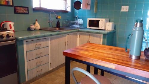 a kitchen with a sink and a table with a microwave at Apartamento Céntrico con Balcón in Paysandú