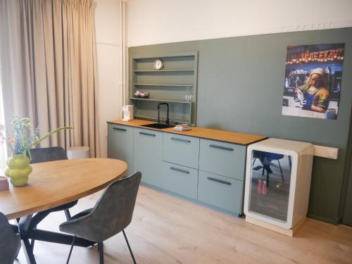 a kitchen with a table and a stove in it at De Kazerne - Kiersche wijde in Wanneperveen