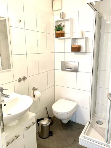 a white bathroom with a toilet and a sink at Leuchtturm in Juist