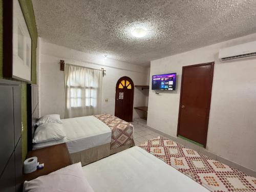 a hotel room with two beds and a tv at Hotel Colonial in Escárcega