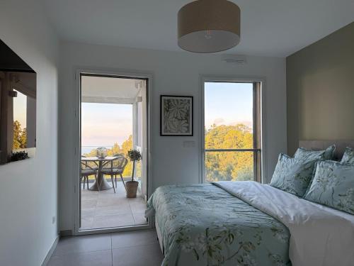 a bedroom with a bed and a balcony with a table at 2-bedroom apartment with breathtaking ocean view in Éze