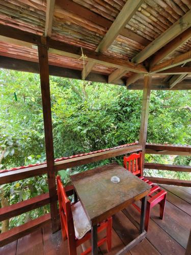 a wooden table and chairs on a wooden deck at Tia's Bamboo Cottages Restaurant, Bar & Sulphur Spa in Roseau
