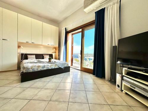 a bedroom with a bed and a large window at MONO SUITE - Rena Bianca in Santa Teresa Gallura
