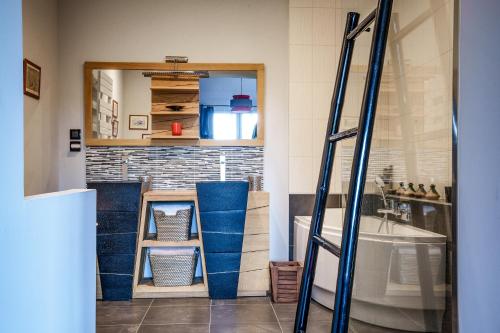 a bathroom with a ladder and a sink and a mirror at Maison avec piscine, proche Chenonceau et Amboise in La Croix-en-Touraine