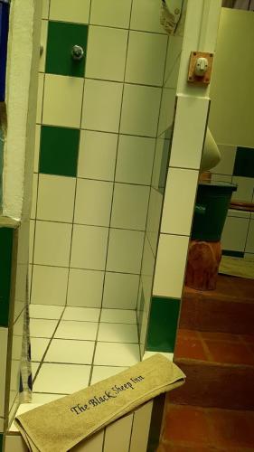 a bathroom with a tiled floor with a sign on it at The Black Sheep Inn in Chugchilán
