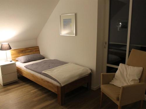 a small bedroom with a bed and a chair at Noorderheven in Niederdorla