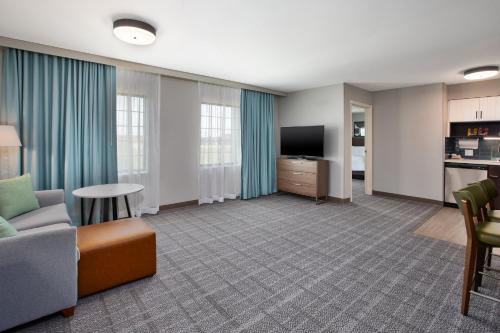a living room with a couch and a tv at Staybridge Suites Bismarck by IHG in Bismarck