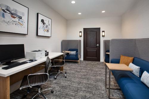 an office with a desk with a computer and chairs at Staybridge Suites Bismarck by IHG in Bismarck