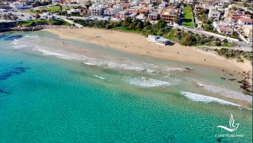 an overhead view of a beach with turquoise water at a casa rà Palumma Rooms in Avola