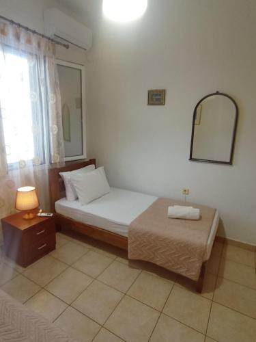 een kleine slaapkamer met een bed en een spiegel bij Sweet Home Lefkas in Lefkada