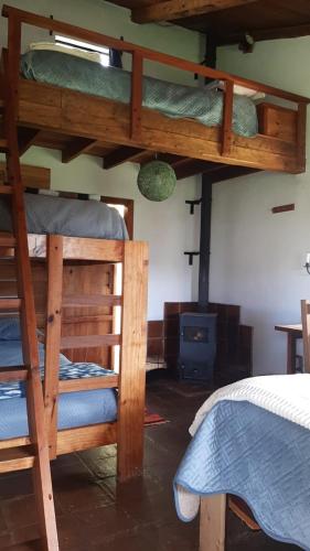 a bedroom with two bunk beds and a stove at The Black Sheep Inn in Chugchilán