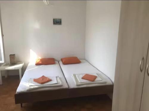 a bed in a room with two pillows on it at Apartmani Dvojak Njivice in Njivice