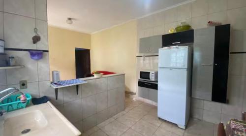 eine Küche mit einem weißen Kühlschrank und einer Spüle in der Unterkunft Casa in Mongaguá