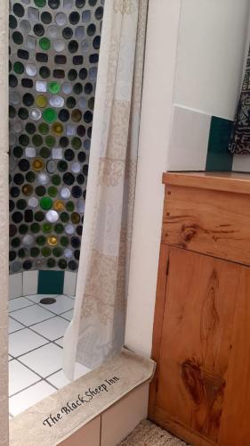 a bathroom with a bunch of wine bottles on the wall at The Black Sheep Inn in Chugchilán