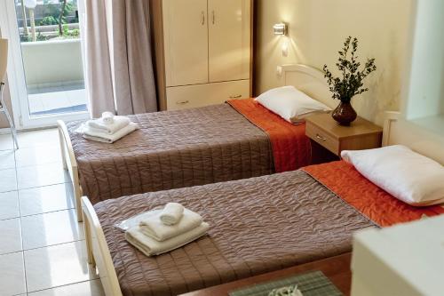 a hotel room with two beds with towels on them at Angela Studios in Karfas
