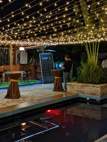 a man standing on a stage with lights and a pool at Inside Afrika Boutique Hotel in Kigali