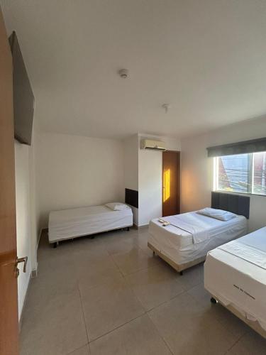ゴイアニアにあるHotel Maria Bonitaのベッド2台と窓のある寝室