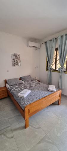 Un dormitorio con una cama de madera en una habitación. en Les cocons du cap santa-clara à Libreville-Gabon, en Lope