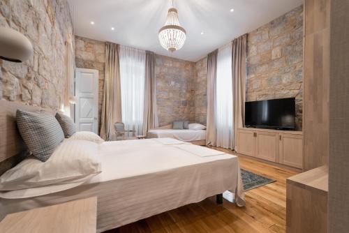 スプリトにあるTifani Luxury Rooms 3の大きな白いベッドとテレビのある寝室