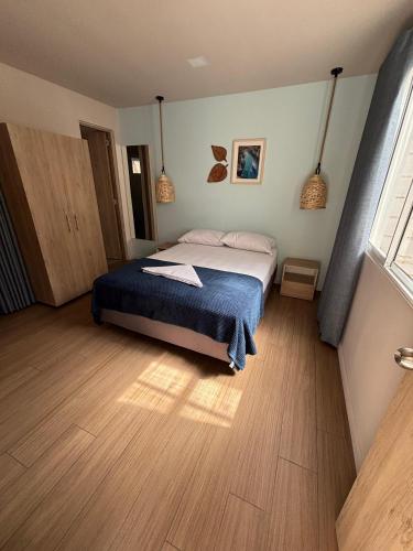 a bedroom with a bed with a blue blanket at Air Guest House - con Desayuno & Jacuzzi Social in Medellín