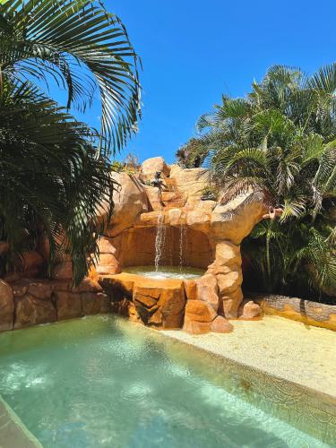 a swimming pool with a waterfall and a water slide at Hospedaje solymar III Sarie Bay in San Andrés