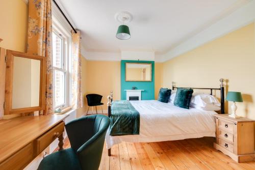 a bedroom with a bed and a desk and a chair at 2 Wissett Cottages in Aldeby