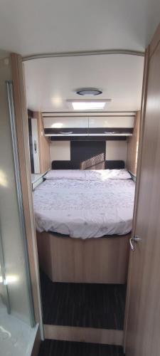 a small bedroom with a bed in the middle at Autocaravana El quijote in Albacete