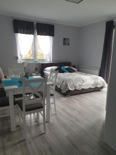 a bedroom with a bed and a table and a desk at Villa6 in Pobierowo