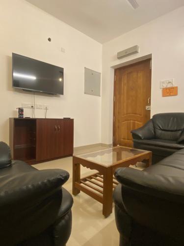 a living room with a couch and a coffee table at 2BHK Lakeview Apartment in chennai in Siruseri