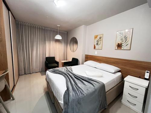 a bedroom with a bed and a desk and a chair at MUV403 - Modern Studio in the Center in Curitiba