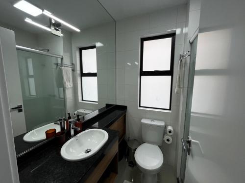 a white bathroom with a sink and a toilet at MUV403 - Modern Studio in the Center in Curitiba