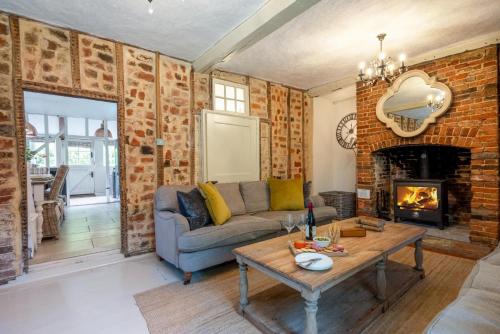 a living room with a couch and a fireplace at Church Farm in Halesworth