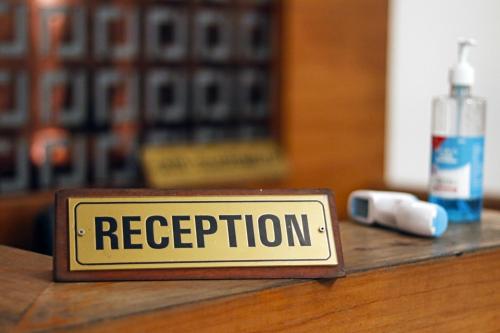 a sign that says reception sitting on a table at OAK Edassery's Sealine Villa Stay in Cochin