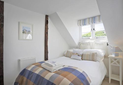 ein weißes Schlafzimmer mit einem Bett in einem Zimmer in der Unterkunft Oyster Cottage in Southwold
