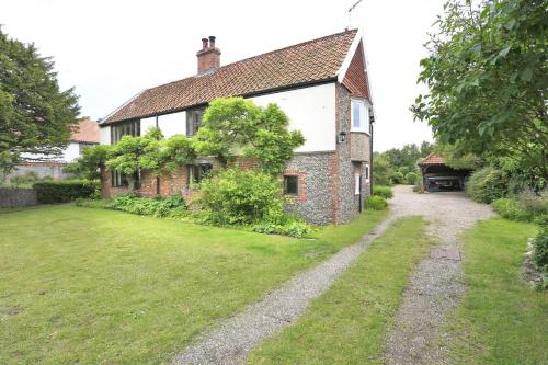an old brick house with a yard in front of it at Old Farm in Walberswick