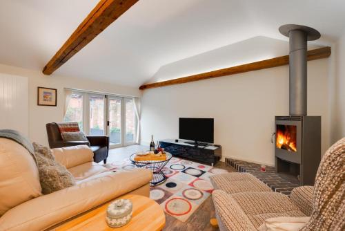 a living room with a couch and a fireplace at The Stables in Ufford