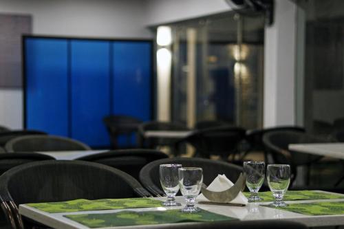 a table with wine glasses on top of it at OAK Edassery's Sealine Villa Stay in Cochin