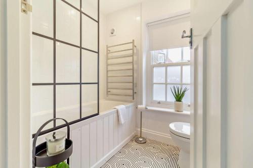 ein weißes Bad mit einem WC und einem Fenster in der Unterkunft Cornfield Terrace in Southwold