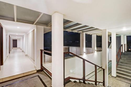 a staircase in a house with white walls and columns at OAK Edassery's Sealine Villa Stay in Cochin