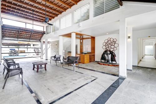 a living room with chairs and a fireplace at OAK Edassery's Sealine Villa Stay in Cochin