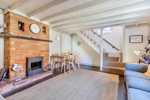 a living room with a brick fireplace and a table at The Anchorage in Sheringham