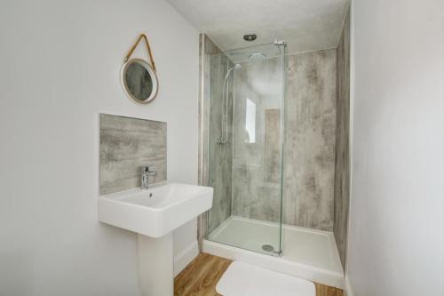 une salle de bain avec lavabo et douche dans l'établissement Dottys Cottage, à Blakeney