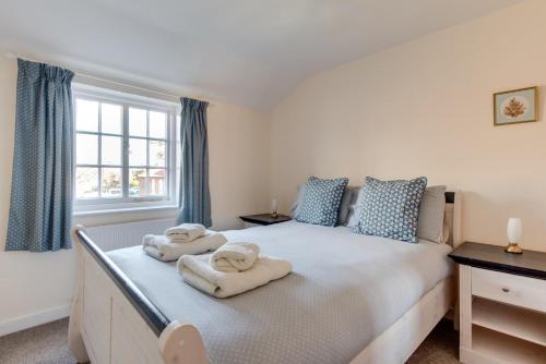 a bedroom with a large bed with towels on it at 30 Victoria Street in Southwold